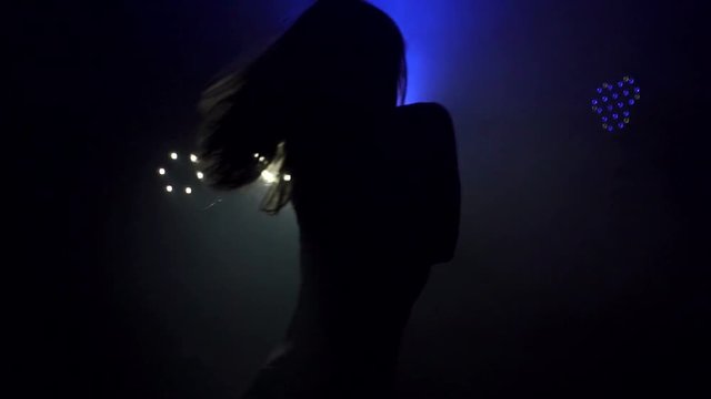 Silhouette of a sexy female pole dancing on black background. Slow motion. Smoke.