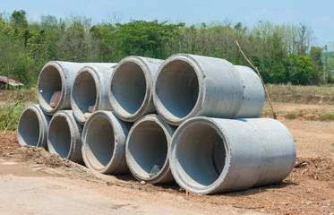 Pile of Concrete Drainage Pipe on a building Site .Concrete pipe stacked sewage water system aligned on construction site.