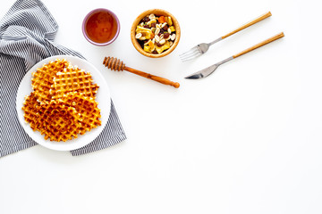 Traditional belgian waffles with dried fruit, nuts and caramel on white background top view copy space