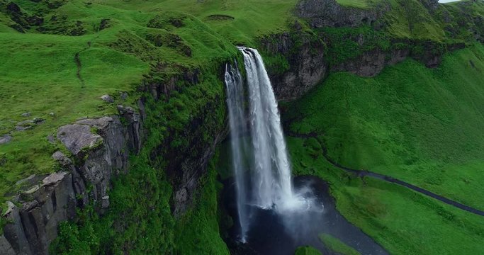 Aerial view of dramatic giant waterfall Seljalandsfoss flowing in Iceland in slow motion 