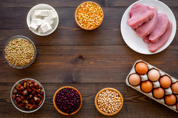 Healthy food. Products rich protein and fiber. Legumes, nuts, low-fat cheese, meet, eggs. Raw beans, chickpeas, lentil, almond, hazelnut on dark wooden background top view copy space