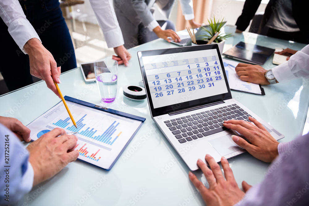 Aufkleber businesspeople using calendar while analyzing graphs