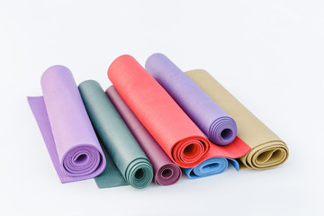 assortment of multicolored rugs for sport and yoga isolated on a white background