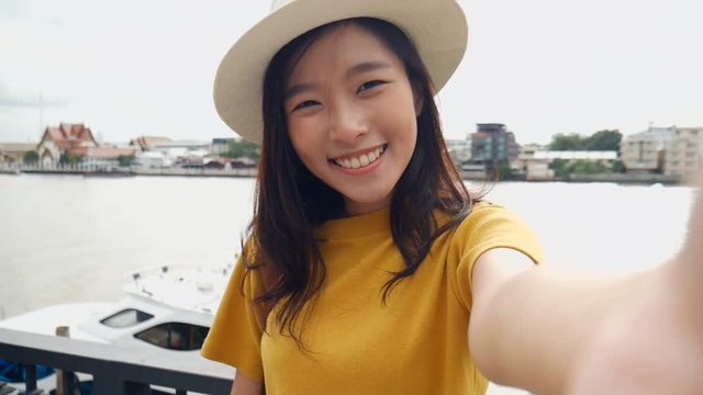 Beautiful asian woman taking selfies on a smartphone. Young asian girl tourist travel to thailand.