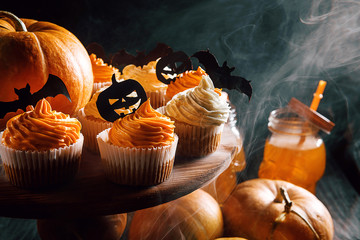 cupcake and pumpkin on a dark background. sweets for the celebration of Halloween.