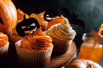 cupcake and pumpkin on a dark background. sweets for the celebration of Halloween.