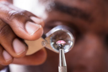 Jeweler Examining Diamond Through Loupe