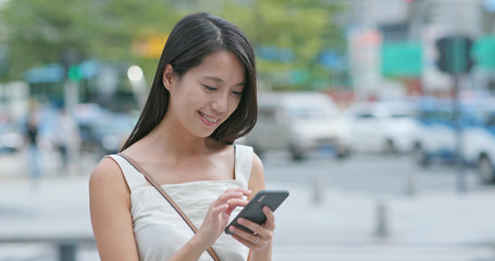 Woman use the app on mobile phone at outdoor