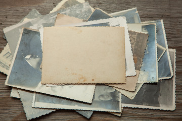 Stack old photos on table. Mock-up blank paper. Postcard rumpled and dirty vintage