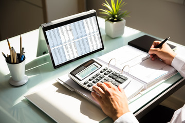 Fototapeta premium Businessman calculating invoice using calculator