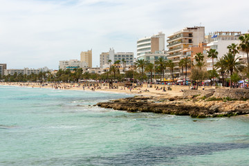 View over the turquoise Mediterranean to the big beach of Cala Millor with its promenade and the many hotels on the Spanish holiday island Mallorca