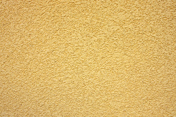 Bright stucco yellow wall background or texture