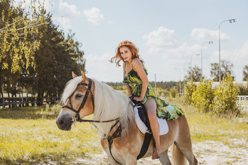 Nice red hair girl at countryside with a horse. A beautiful rider and horse. Artistic Photography at horse farm. Attractive girl riding on horse rural location at autumn 