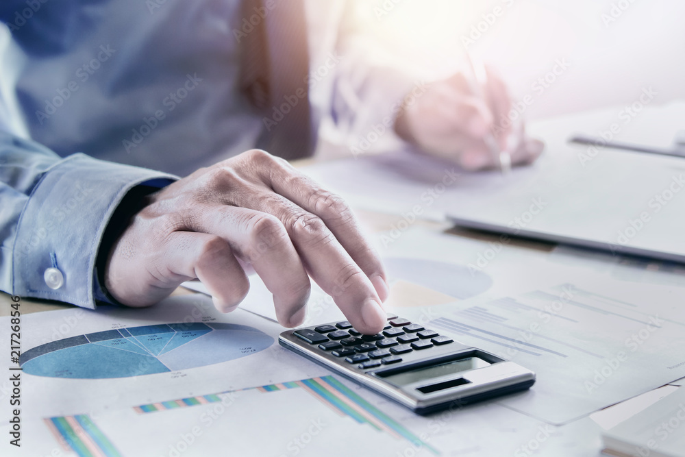 Poster businessman working on desk using calculator for calculate accounting report in office