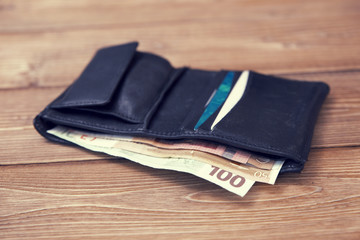 old black purse on a wooden table
