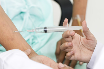 Close up focus.Hand of doctor inject vaccine to patient.Copy space.