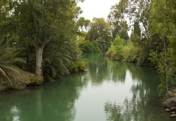 The calm running River Jordan at the Yardenit Baptismal Site the traditional place of John the...