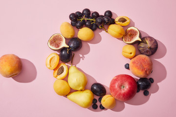 top view of fresh ripe sweet tasty fruits on purple background
