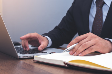 Young business man working on laptop, man's hands on laptop at workplace