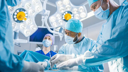 Diverse Team of Professional surgeon,  Assistants and Nurses Performing Invasive Surgery on a...