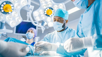 Diverse Team of Professional surgeon, Assistants and Nurses Performing Invasive Surgery on a...