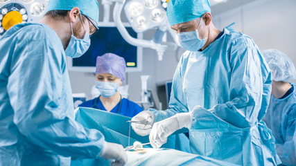 Diverse Team of Professional surgeon,  Assistants and Nurses Performing Invasive Surgery on a...