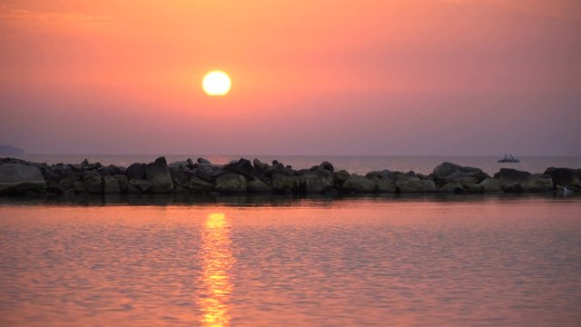 4K scenic red sunrise background sun rising. Close up video of sun rising behing sea