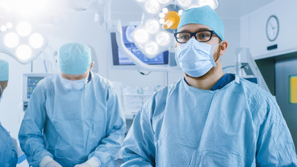 In the Operating Room Surgeon Gestures Using Augmented Reality Technology During Operation. In the Background Assistants and Nurses Working with Real Equipment.