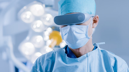In the Hospital Operating Room Professional Surgeon Wears Virtual Reality Glasses.