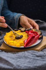 Woman tastes arabic chickpea hummus, roasted red pepper and grilled crispy eggplant slices. Homemade vegetarian healthy food. Ideal vegetables vegan lunch