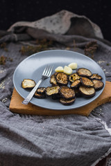 Crust roasted eggplants slices on stylish grey plate. Sprinkled with herbs, black pepper and garlic powder. Perfect vegan dish without refined oil. Delicious vegetarian lunch. Vegetables small portion