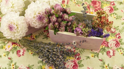 Fresh and dry flowers on the fabric with floral pattern, floral arrangement