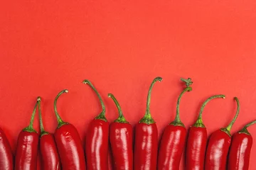 Fotobehang Chilli pepper on a red background with copy space. © WindyNight