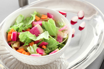 Fresh salad with sliced radish and lettuce in bowl