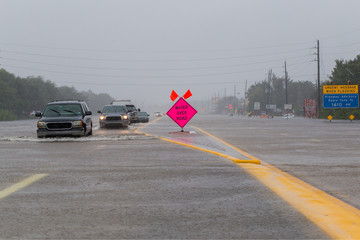 Cars drive on flooded highway. Heavy rains from hurricane caused many flooded roads in the city and its suburbs, many roads and highways are impassable