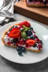 Plate with piece of delicious berry pie on table