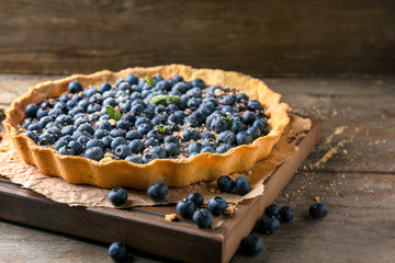 Delicious blueberry pie on wooden table