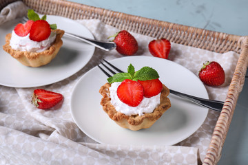 Plates with delicious tartlets in wicker tray