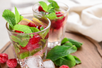 Glass of fresh raspberry mojito on table, closeup