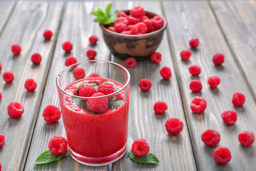 Glass of tasty raspberry smoothie on wooden table