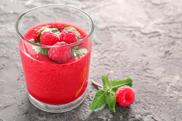 Glass of tasty raspberry smoothie on table