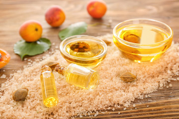 Sea salt and apricot essential oil on wooden table