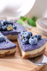 Taking of tasty blueberry cheesecake from board by using shovel, closeup