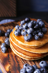 Tasty pancakes with blueberries on board