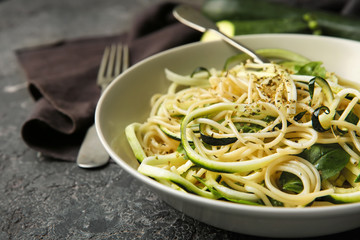 Plate of spaghetti with zucchini on table, closeup