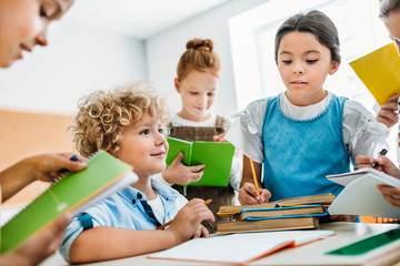 schoolchildren writing off homework of their classmate during break