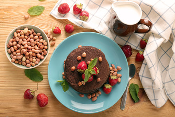 Fototapeta na wymiar Plate with tasty chocolate pancakes on wooden table