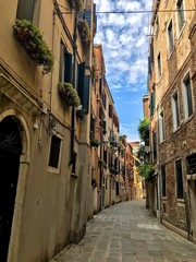 View of the cosy street with colorful buildings, old doors and windows in Venice, Italy.