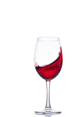A splash of wine in a glass. A splash of red wine. A glass with red wine on a white background.