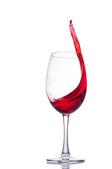 A splash of wine in a glass. A splash of red wine. A glass with red wine on a white background.